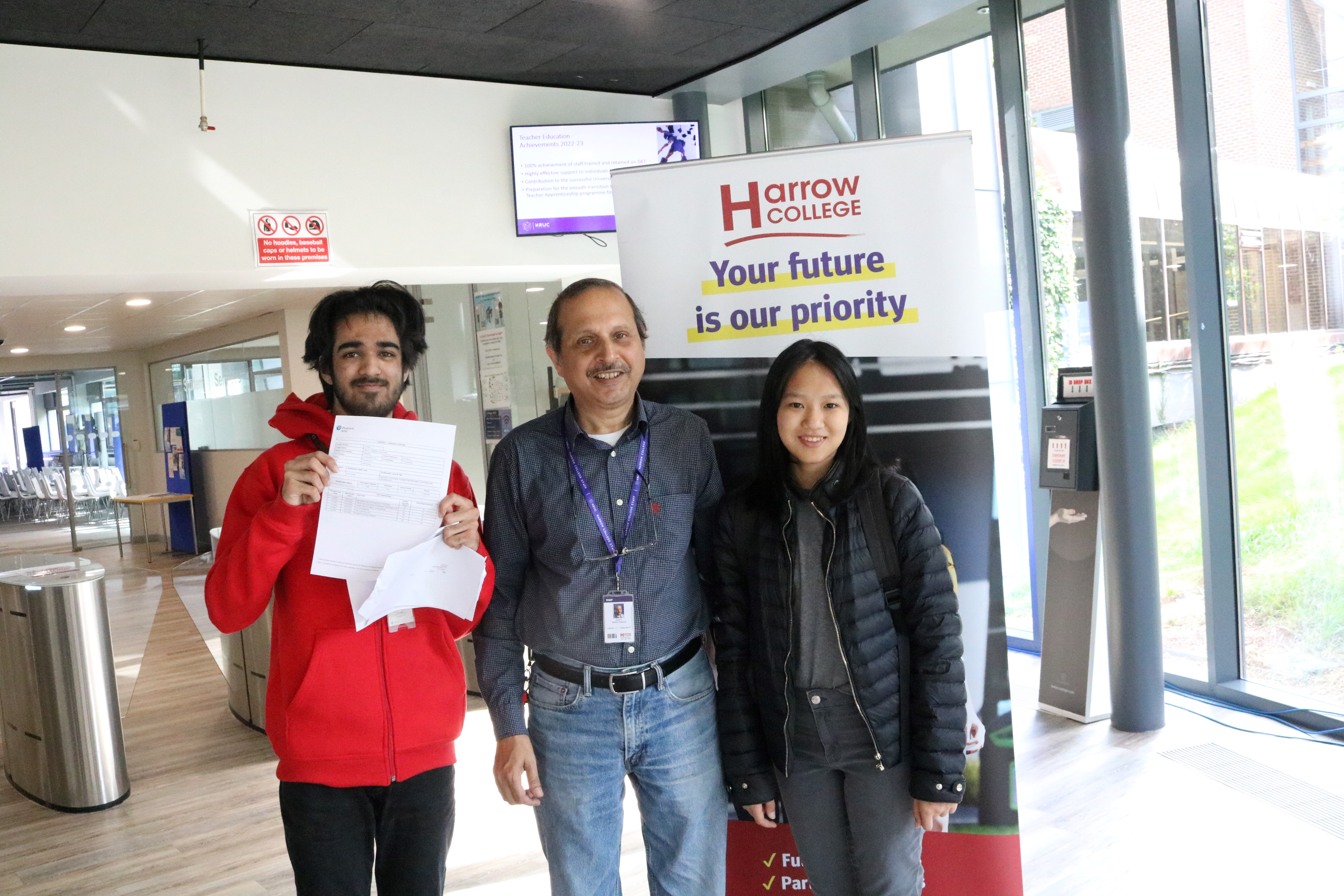 Group of three people looking happily into the camera after opening their results