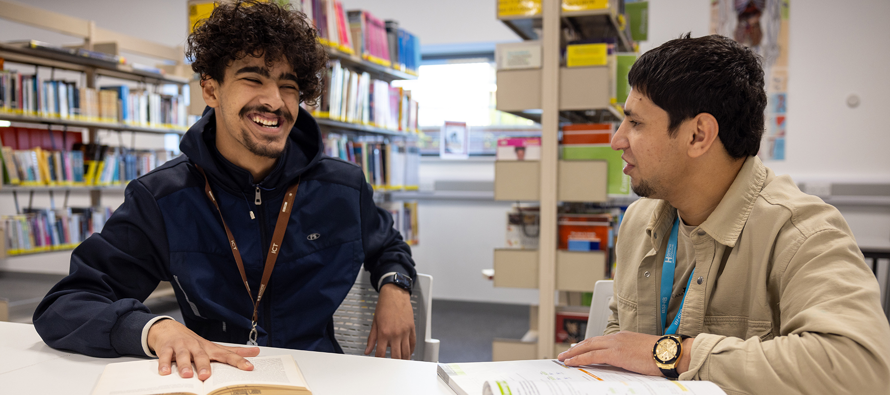 2 x male Harrow on the Hill students working together and smiling in the Learning Resource Centre.