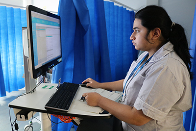 Project Search Supported Internship Program student at Northwick Park Hospital, looking up information on the computer.